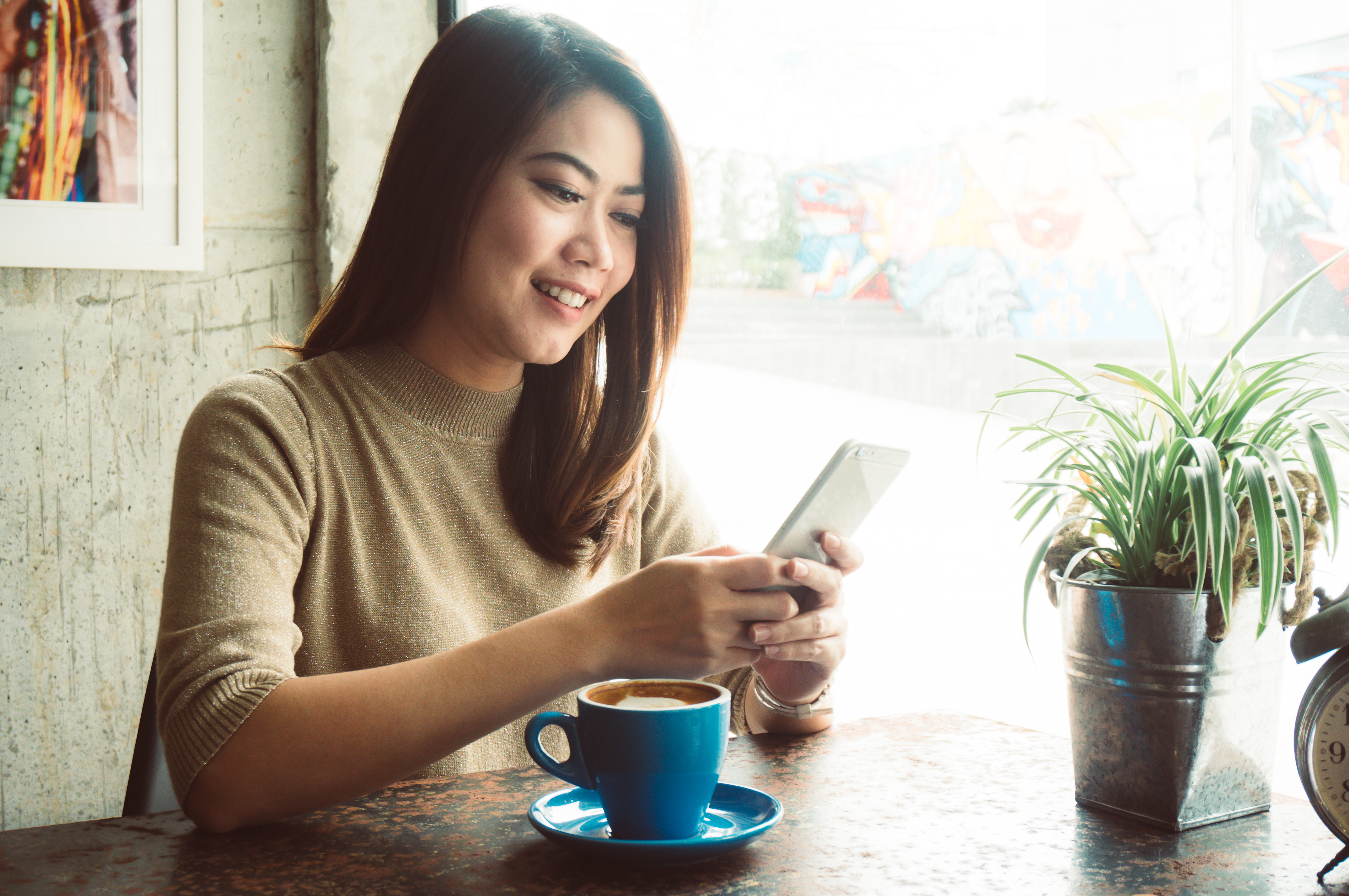 A young woman smiles at how easy it is for an overdraft transfer to go through.