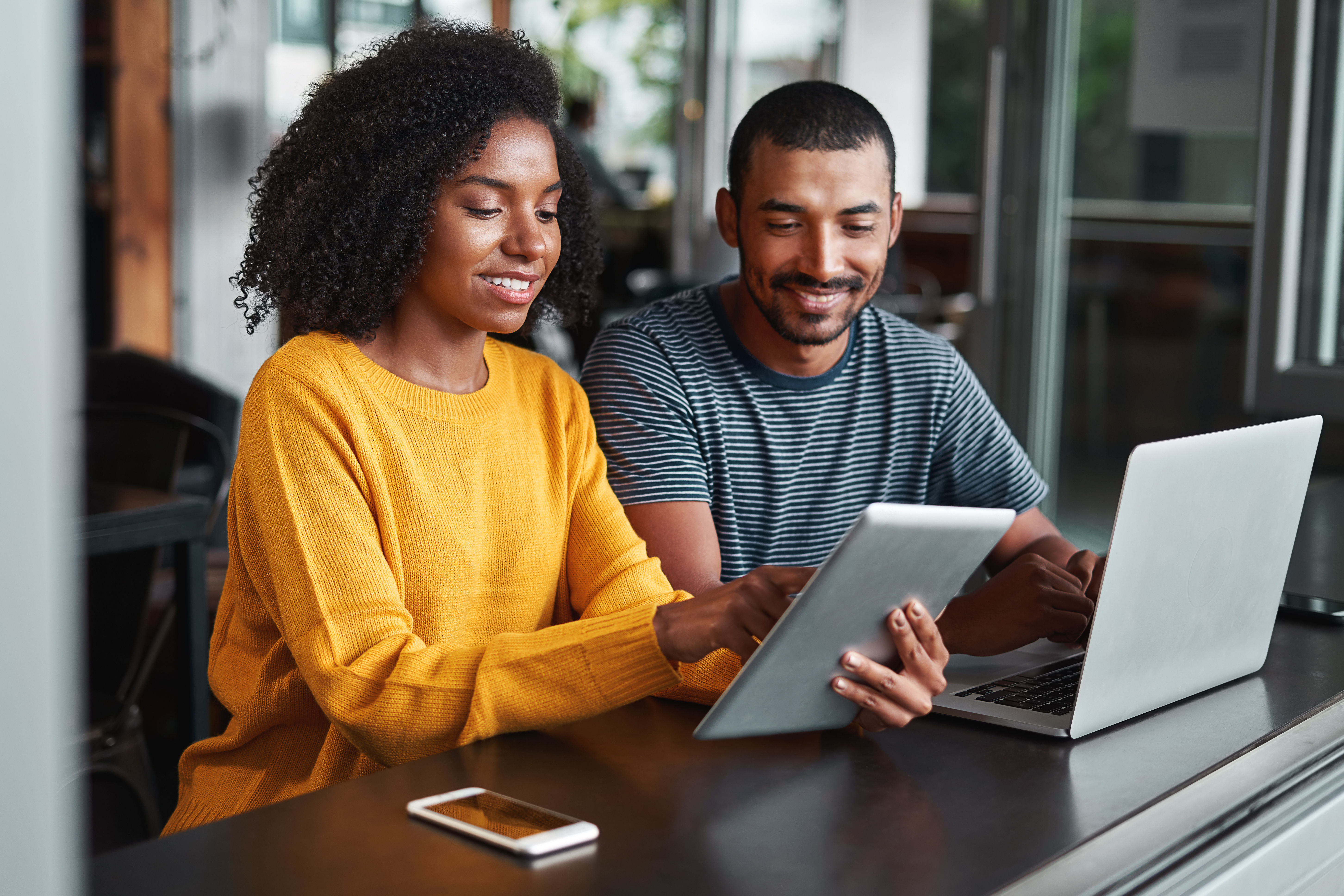 A young couple sign up for checking account overdraft protection online.